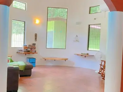 a living room with a couch and some windows at Casa Redonda Tranquil House 15 Minutes from Samara by Car in Nicoya