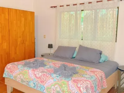 a bedroom with a bed with two pillows and a window at Casa Redonda Tranquil House 15 Minutes from Samara by Car in Nicoya