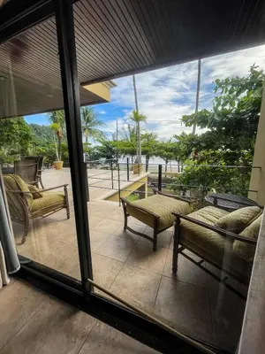 a living room with a view of a patio at Beachfront Terrace Sunset 3B in Jacó