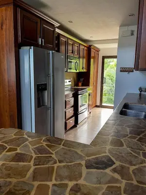 a kitchen with a stainless steel refrigerator and a sink at Beachfront Terrace Sunset 3B in Jacó