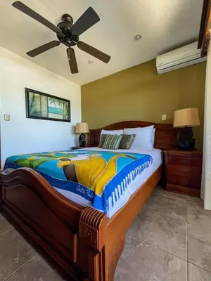 a bedroom with a large bed with a ceiling fan at Beachfront Terrace Sunset 3B in Jacó