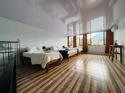 a bedroom with two beds and a large window at SUA Luxury Arenal Volcano View Apartments in Fortuna