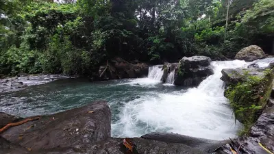 a waterfall in the middle of a river at SUA Luxury Arenal Volcano View Apartments in Fortuna