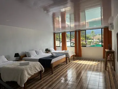 a bedroom with two beds and a large window at SUA Luxury Arenal Volcano View Apartments in Fortuna