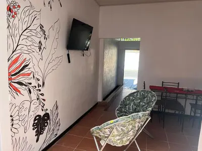 a room with two chairs and a tv on a wall at Buganvilla Quepos Dos in Tapantí