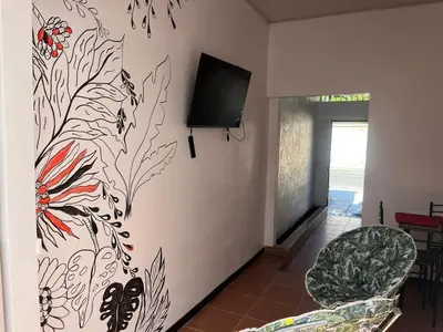 a living room with a tv on a wall at Buganvilla Quepos Dos in Tapantí