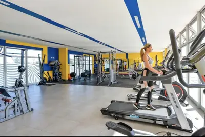 a woman walking on a treadmill in a gym at Luxury 12th Floor Apartment with Views - Downtown San Jose Pool and Gym in San José