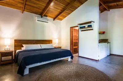 a bedroom with a bed with a blue bedspread at The Sunset Shack in Nosara
