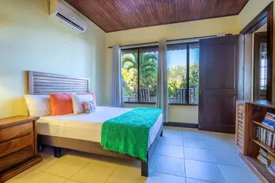 a bedroom with a bed and a window at Villa Cielo in Jacó