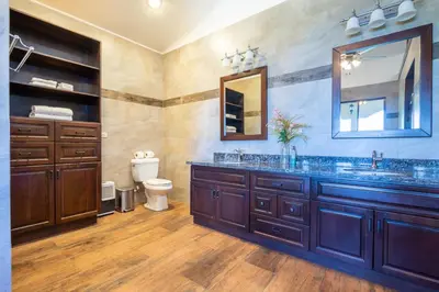 a bathroom with a sink and a toilet and a mirror at Villa Cielo in Jacó