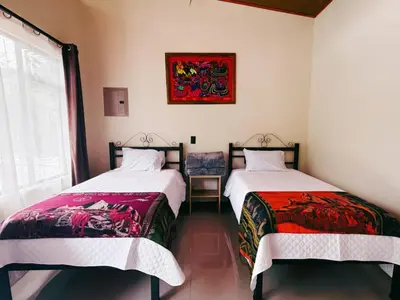 two beds sitting next to each other in a room at Cabinas Las Veraneras - Dota in Santa María