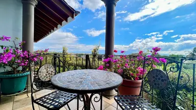 a table and chairs on a balcony with flowers at Ruta Verde BB in Tambor