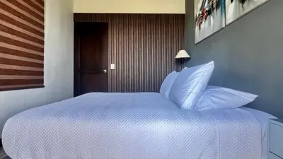 a bed with white sheets and pillows in a room at Ruta Verde BB in Tambor