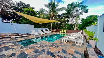 a patio with a hammock and chairs and a pool at Ruta Verde BB in Tambor