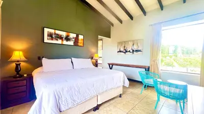 a bedroom with a bed and two chairs and a window at Ruta Verde BB in Tambor