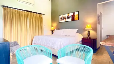 a bedroom with a bed and two chairs at Ruta Verde BB in Tambor