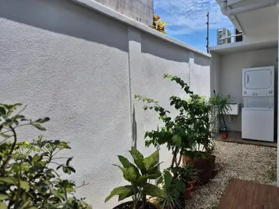 a white wall with plants on the side of a building at CasaMar 2BD & 2BA in Jacó