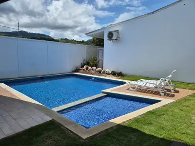 a swimming pool in a yard next to a house at CasaMar 2BD & 2BA in Jacó