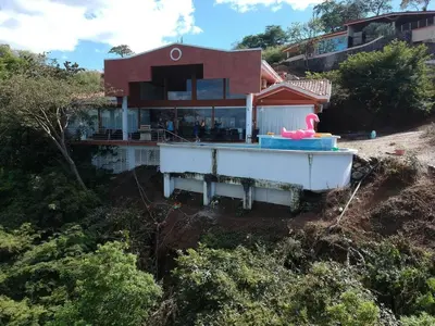 a house with a boat in front of it at Hermosa Heights Villa 58 in Playa Hermosa