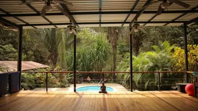 a patio with a pool with a person in the middle at Believe Surf & Yoga Lodge Santa Teresa in Santa Teresa Beach