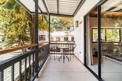 a balcony with a table and chairs at Believe Surf & Yoga Lodge Santa Teresa in Santa Teresa Beach