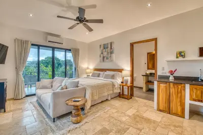 a bedroom with a bed and a couch at Blue Jungle Lodge in Arenal