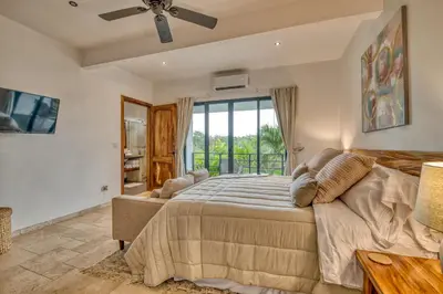 a bedroom with a large bed and a window at Blue Jungle Lodge in Arenal