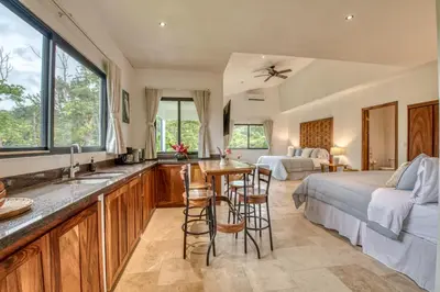 a kitchen and living room with a bed and a sink at Blue Jungle Lodge in Arenal