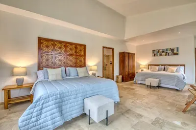 a bedroom with two beds and a table and chairs at Blue Jungle Lodge in Arenal