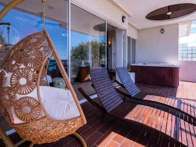a porch with two chairs and a swing at Casa White#2 Beautiful modern beach house in Sámara