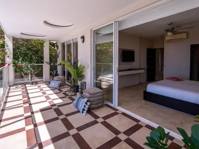 a bedroom with a bed and a checkerboard floor at Casa White#2 Beautiful modern beach house in Sámara