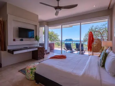 a bedroom with a large bed and a large window at Casa White#2 Beautiful modern beach house in Sámara