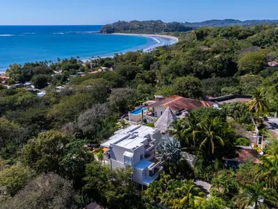 an aerial view of a house on a hill next to the ocean at Casa White Duplex Beautiful beach houses in Sámara