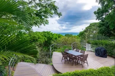 a wooden deck with a table and chairs on it at Casa White Duplex Beautiful beach houses in Sámara