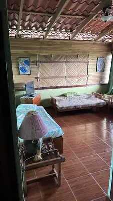 a room with two beds and a lamp on a table at Quinta La Lomita in Turrialba