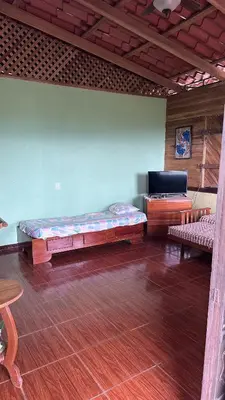a room with two beds and a table in a room at Quinta La Lomita in Turrialba