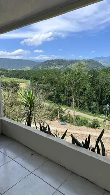 a balcony with a view of a field and trees at Quinta La Lomita in Turrialba