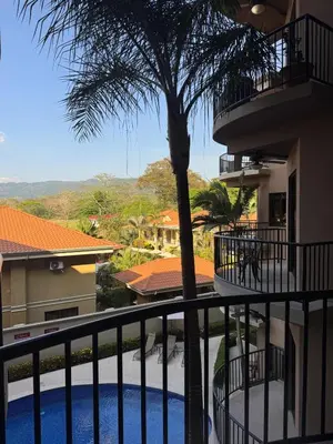 a view from the balcony of a building with a palm tree at Monaco Condominiums, Jacó, Costa Rica - Luxury 3 Bedrooms in Jacó