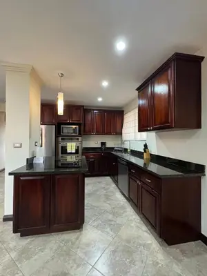 a large kitchen with wooden cabinets and appliances at Monaco Condominiums, Jacó, Costa Rica - Luxury 3 Bedrooms in Jacó