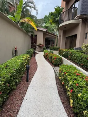 a walkway in front of a building with flowers at Monaco Condominiums, Jacó, Costa Rica - Luxury 3 Bedrooms in Jacó