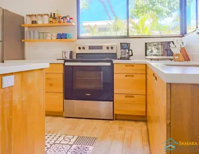 a kitchen with a stove and a sink at Casa Encanto Charming house 5 minutes walking from the beach in Sámara