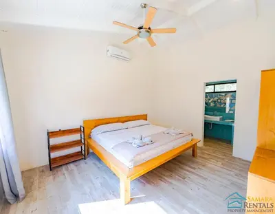 a bedroom with a bed and a ceiling fan at Casa Encanto Charming house 5 minutes walking from the beach in Sámara