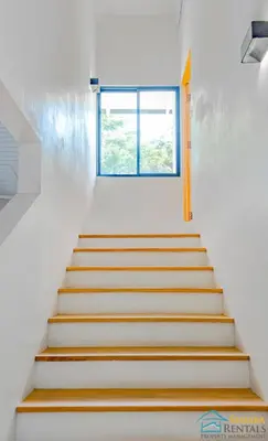 a staircase leading up to a window in a house at Casa Encanto Charming house 5 minutes walking from the beach in Sámara