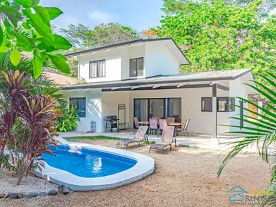a villa with a swimming pool and a house at Casa Encanto Charming house 5 minutes walking from the beach in Sámara