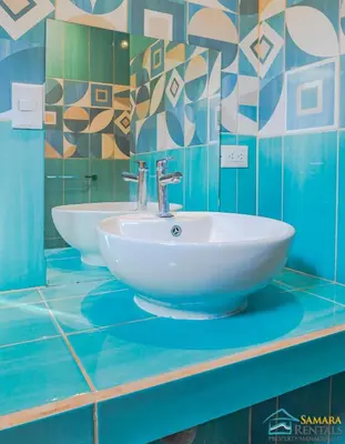 a bathroom with two sinks on a blue counter at Casa Encanto Charming house 5 minutes walking from the beach in Sámara