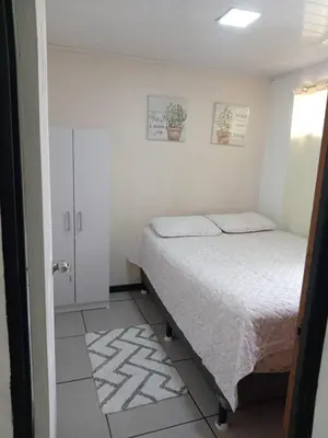 a small bedroom with a bed and a window at Casa Amiga in San José
