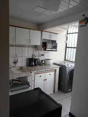 a kitchen with white cabinets and a washer and dryer at Casa Amiga in San José