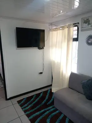 a living room with a couch and a flat screen tv at Casa Amiga in San José