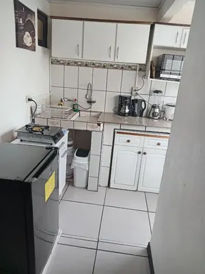 a small kitchen with white cabinets and white appliances at Casa Amiga in San José