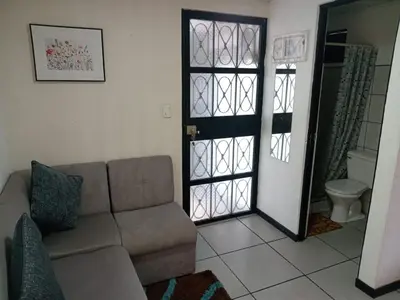 a living room with a couch and a toilet at Casa Amiga in San José